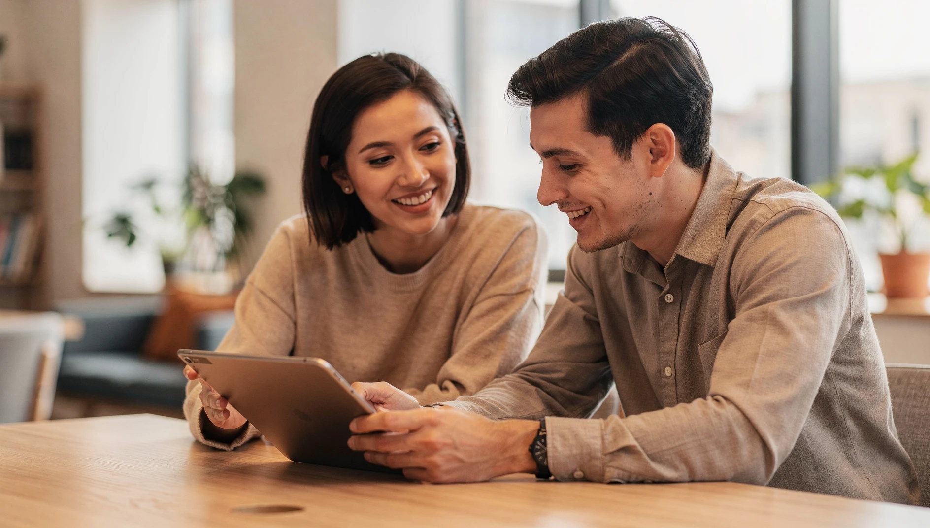 Two professionals collaborating and sharing ideas in a bright modern workspace