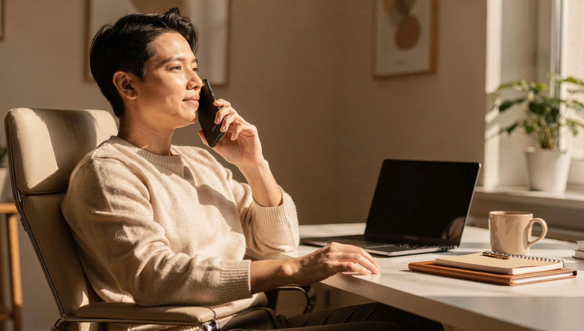 A person recording a short voice note on their phone at a home office desk with warm natural light