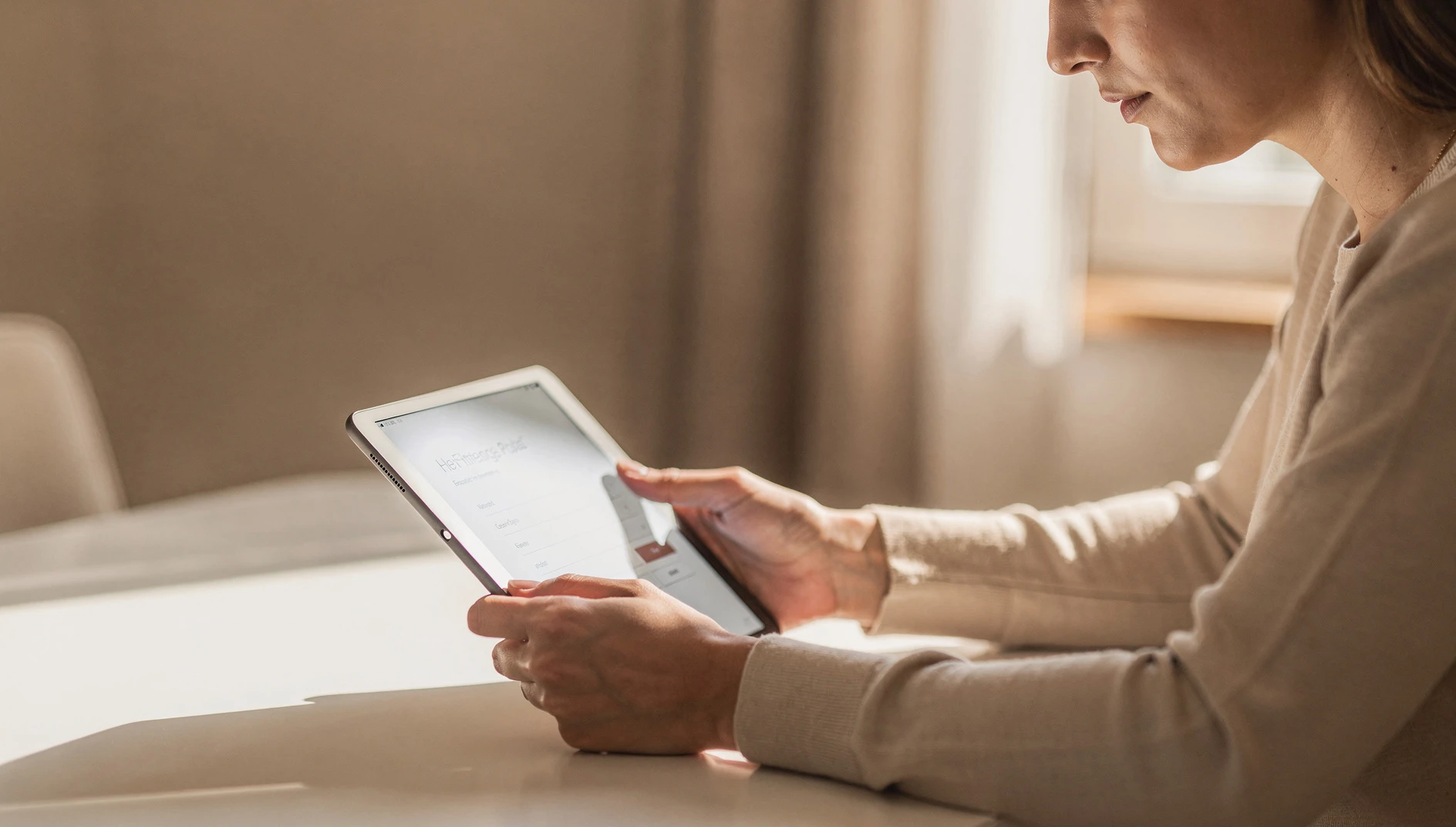 A person filling out a form on a tablet at a clean table with natural light